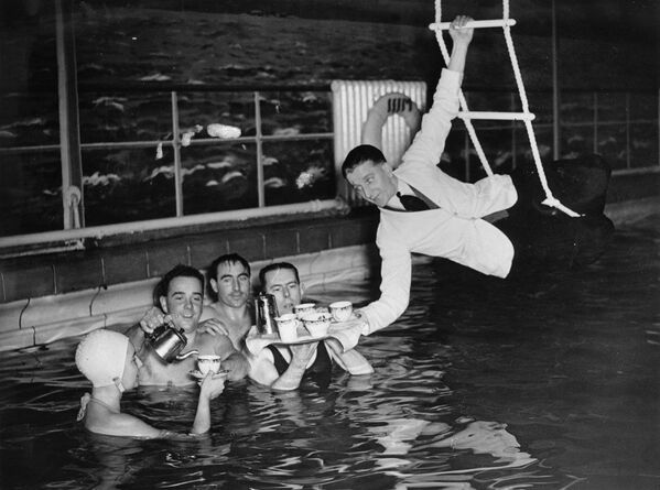 لقطة طريفة لنادل يقدم الشاي للضيوف في مسبح نادي ميلونز للغولف في كارديف في المملكة المتحدة عام 1937. - سبوتنيك عربي