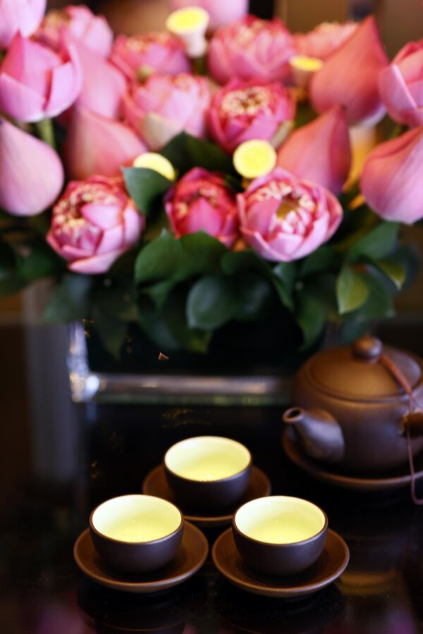 صورة لثلاثة أكواب من الشاي وزهور اللوتس، خلال حفل لاحتساء الشاي. - سبوتنيك عربي