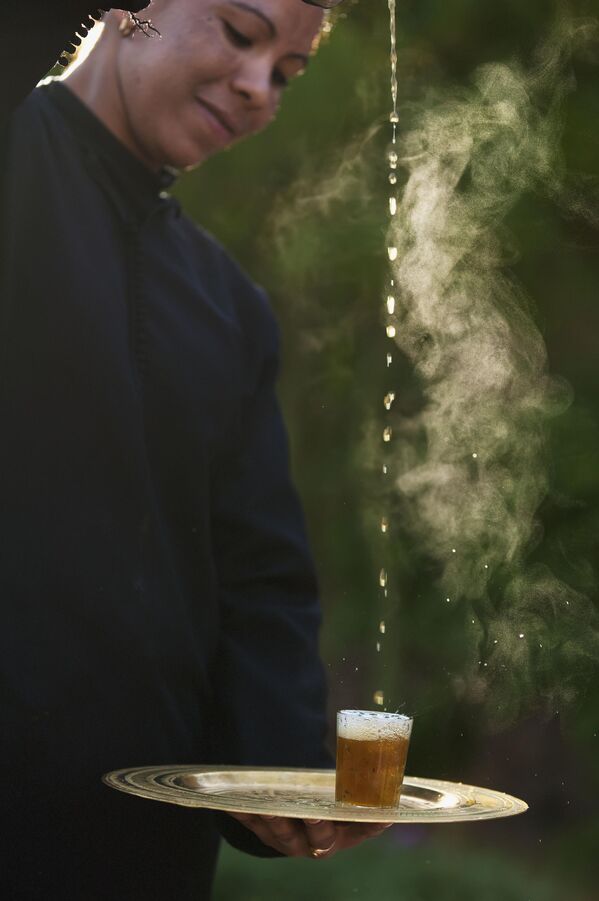 نادلة تسكب شاي النعناع المغربي في كوب من ارتفاع عالٍ، في فندق دار الأحلام، الغرب. - سبوتنيك عربي