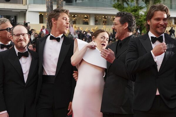 الممثلة الأمريكية، إيما ستون، تتفادى نحلة أثناء التقاط صورة مع الممثل خواكين فينيكس، من اليسار، والمخرج آري أستر - سبوتنيك عربي