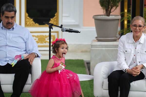 الرئيس الفنزويلي نيكولاس مادورو (يسار) مع السيدة الأولى سيليا فلوريس (يمين)، والطفلة، مايكيليس إسبينوزا برنال، البالغة من العمر عامين، بعد أن سلمتها السلطات الأمريكية إلى فنزويلا، عقب احتجازها لفترة إثر ترحيل والديها بشكل منفصل - سبوتنيك عربي