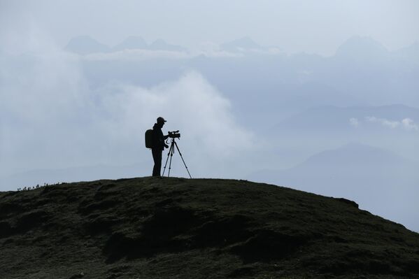 مصور فيديو يظهر في صورة ظلية أثناء تصويره لمنطقة سايلونغ في دولاخا.  - سبوتنيك عربي