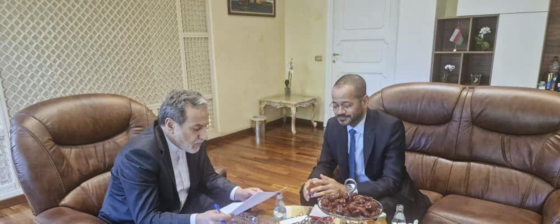 وزير الخارجية الإيراني، عباس عراقجي، يقرأ ورقة في اجتماع مع نظيره العماني، بدر البوسعيدي، في السفارة العمانية في روما، خلال الجولة الخامسة من المفاوضات الإيرانية الأمريكية، 23 مايو/ أيار 2025 - سبوتنيك عربي, 1920, 23.05.2025