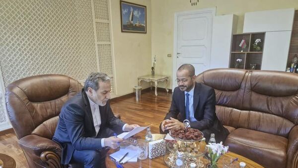 وزير الخارجية الإيراني، عباس عراقجي، يقرأ ورقة في اجتماع مع نظيره العماني، بدر البوسعيدي، في السفارة العمانية في روما، خلال الجولة الخامسة من المفاوضات الإيرانية الأمريكية، 23 مايو/ أيار 2025 - سبوتنيك عربي