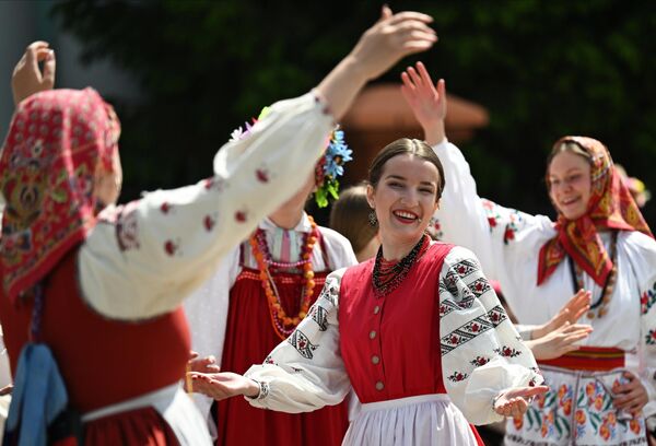 فتيات مشاركات في المهرجان يرقصن وهن يرتدين الأزياء التقليدية. - سبوتنيك عربي