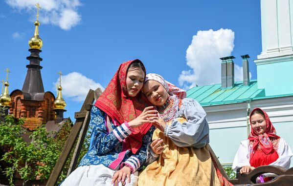 فتاتان ترتديان الزي التقليدي لقرية نيكولسكوي، أثناء التقاط صورة تذكارية لهما. - سبوتنيك عربي