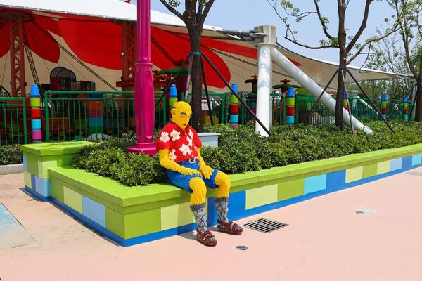 مجسم لطفل يجلس على حافة حديقة صغيرة أمام مجموعة ألعاب.  - سبوتنيك عربي