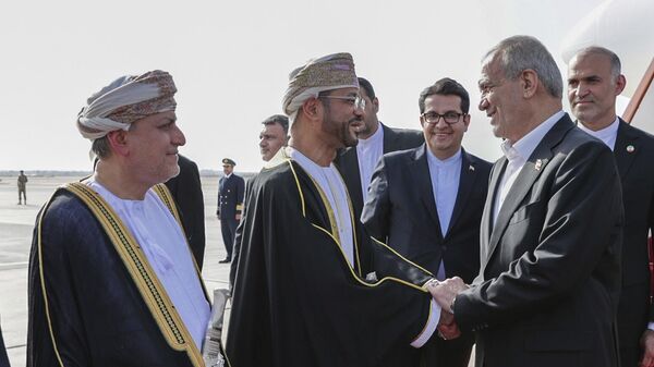 الرئيس الإيراني، مسعود بزشكيان، يصافح وزير الخارجية العماني، بدر البوسعيدي لدى وصوله إلى مسقط، سلطنة عمان، 27 مايو/ أيار 2025 - سبوتنيك عربي