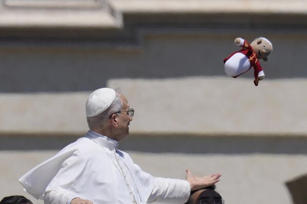 البابا ليون الرابع عشر يلتقط دمية صغيرة تمثل البابا بعد مقابلته العامة الأسبوعية في ساحة القديس بطرس في الفاتيكان. - سبوتنيك عربي