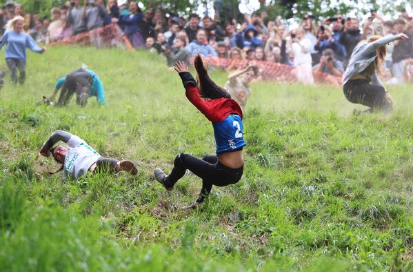 متسابقات خلال مشاركتهن في مسابقة تدحرج الجبن السنوية للسيدات في بروكوورث، إنجلترا - سبوتنيك عربي