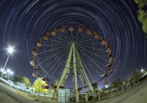 محطة الفضاء الدولية (ISS) تتحرك في خط مستقيم عبر السماء من اليسار إلى اليمين، على طول مدارها فوق عجلة فيريس في قاعدة بايكونور. - سبوتنيك عربي