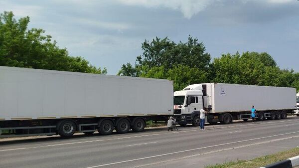 صحفيون لوسائل إعلام أجنبية أمام الشاحنات التي تحمل جثث الجنود الأوكرانيين التي رفض نظام كييف تسلمها - سبوتنيك عربي