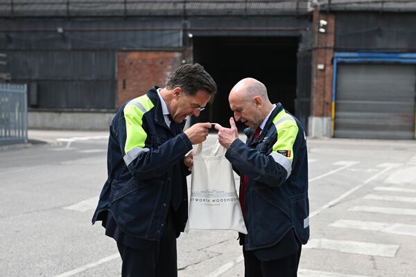 وزير الدفاع البريطاني جون هيلي (يسار) والأمين العام لحلف شمال الأطلسي مارك روته ينظران إلى حقيبة هدايا أثناء زيارتهما لمصنع شيفيلد في إنجلترا. - سبوتنيك عربي