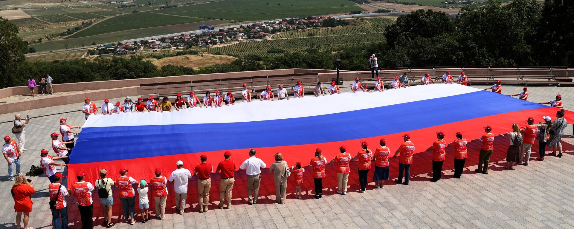 سكان مدينة سيفاستوبول يفرشون العلم الروسي بطول 200 متر على جبل سابون في يوم روسيا. - سبوتنيك عربي, 1920, 22.08.2025