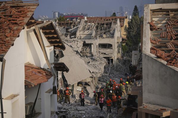 قوات الأمن الإسرائيلية تتفقد المنازل المدمرة التي أصابها صاروخ أطلق من إيران، في ريشون لتسيون، إسرائيل، يوم السبت 14 يونيو/حزيران 2025. - سبوتنيك عربي