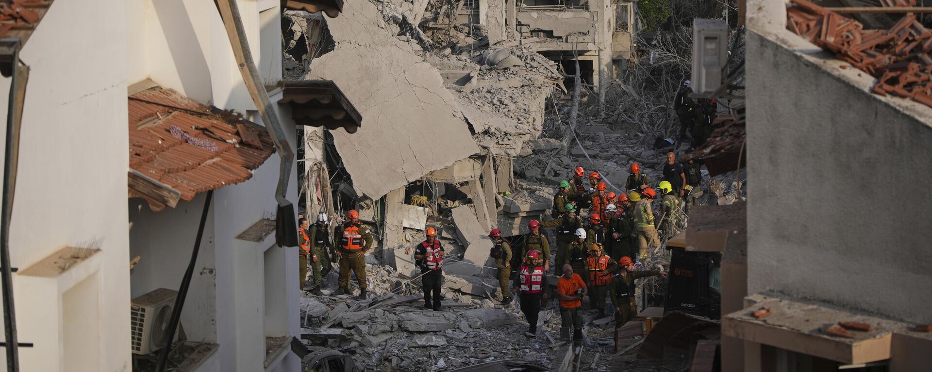 قوات الأمن الإسرائيلية تتفقد المنازل المدمرة التي أصابها صاروخ أطلق من إيران، في ريشون لتسيون، إسرائيل، يوم السبت 14 يونيو/حزيران 2025. - سبوتنيك عربي, 1920, 14.06.2025