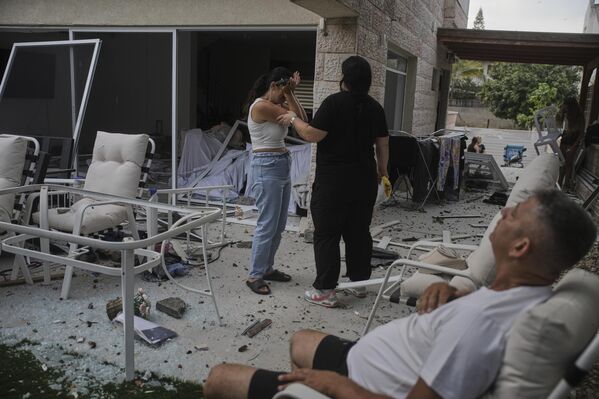 يتفاعل السكان بعد إصابة منزلهم بصاروخ أطلق من إيران، في ريشون لتسيون، إسرائيل، يوم السبت 14 يونيو 2025. - سبوتنيك عربي