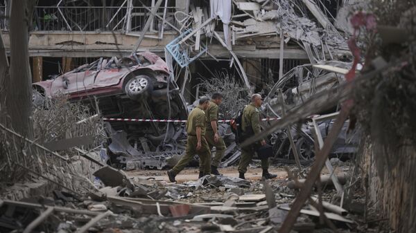 قوات الأمن الإسرائيلية تتفقد المباني السكنية المدمرة التي أصابتها صاروخ أطلق من إيران، في رامات جان، بالقرب من تل أبيب، إسرائيل، يوم السبت 14 يونيو 2025. - سبوتنيك عربي
