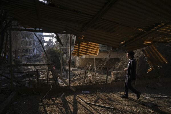 شخص ينظر إلى مبنى سكني مدمر أصيب بصاروخ أطلق من إيران، في رامات جان، بالقرب من تل أبيب، إسرائيل، يوم السبت 14 يونيو 2025. - سبوتنيك عربي