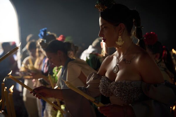 حجاج يشعلون الشموع في مزار "إل روسيو" بالقرب من أزنالكازار، إسبانيا، يوم السبت 7 يونيو/حزيران 2025، خلال الحج السنوي الذي يتجمع فيه مئات الآلاف من أتباع "عذراء ديل روسيو" داخل وحول المزار. - سبوتنيك عربي