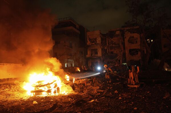 رجال الإطفاء يعملون على إخماد حريق بعد سقوط صاروخ أطلق من إيران على تل أبيب. - سبوتنيك عربي