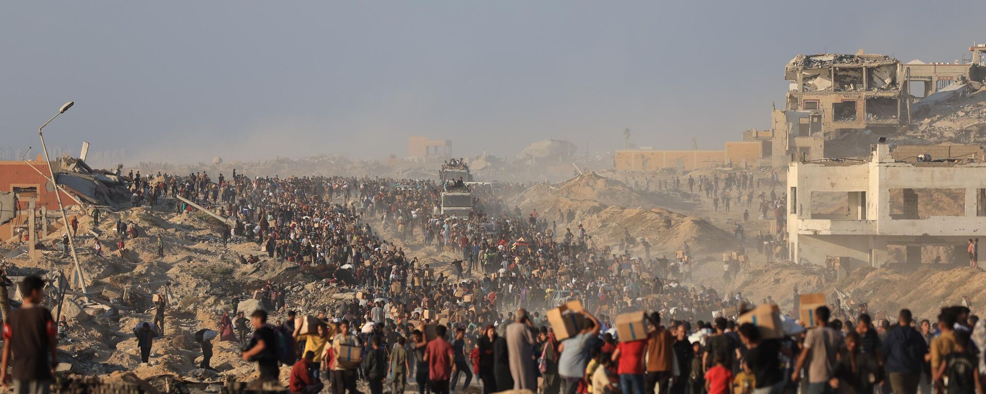 فلسطينيون يحملون صناديق المساعدات الإنسانية، بينما يعاني الناس من الجوع خلال الهجمات الإسرائيلية المستمرة على قطاع غزة - سبوتنيك عربي, 1920, 18.07.2025