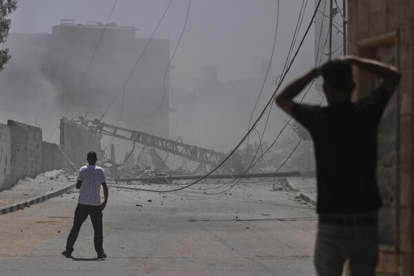 فلسطينيون يتفقدون الأضرار التي لحقت بمنزل دمره القصف الإسرائيلي في قطاع غزة - سبوتنيك عربي