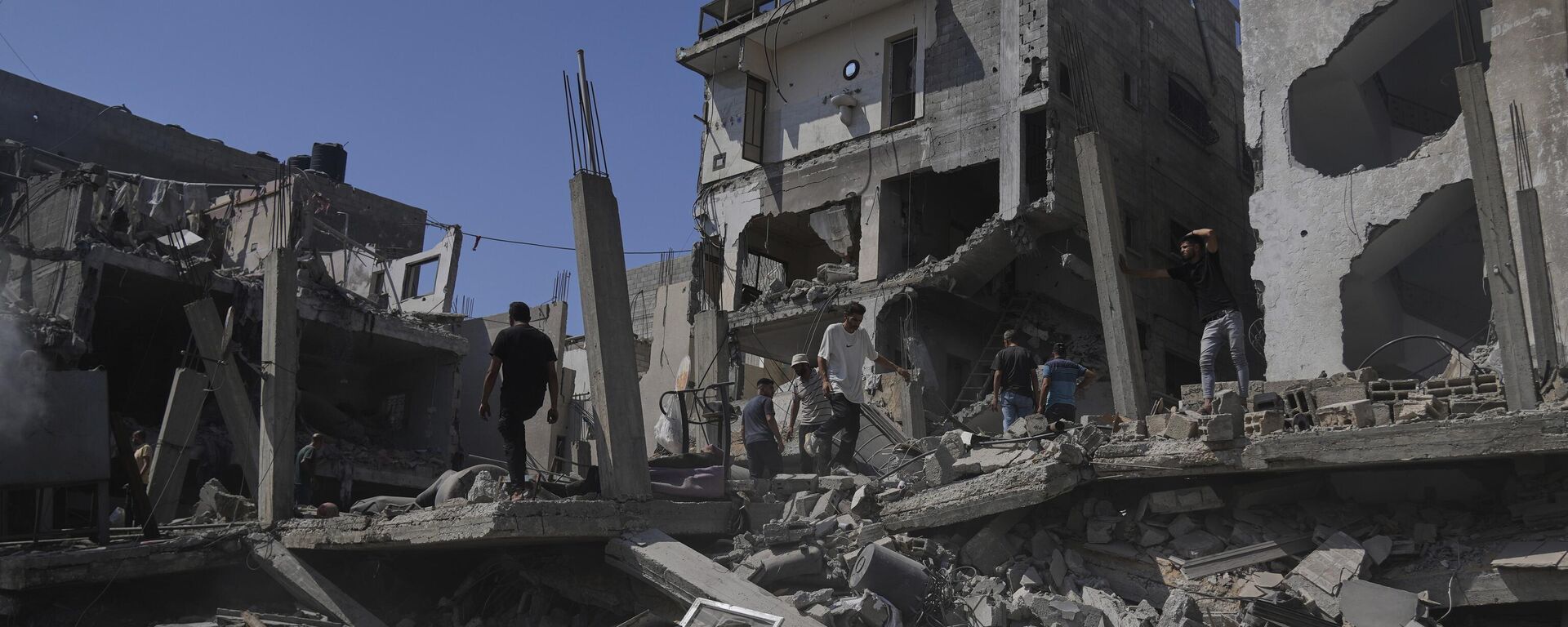 فلسطينيون يتفقدون الأضرار التي لحقت بمنزل دمره القصف الإسرائيلي في دير البلح، وسط قطاع غزة - سبوتنيك عربي, 1920, 22.07.2025