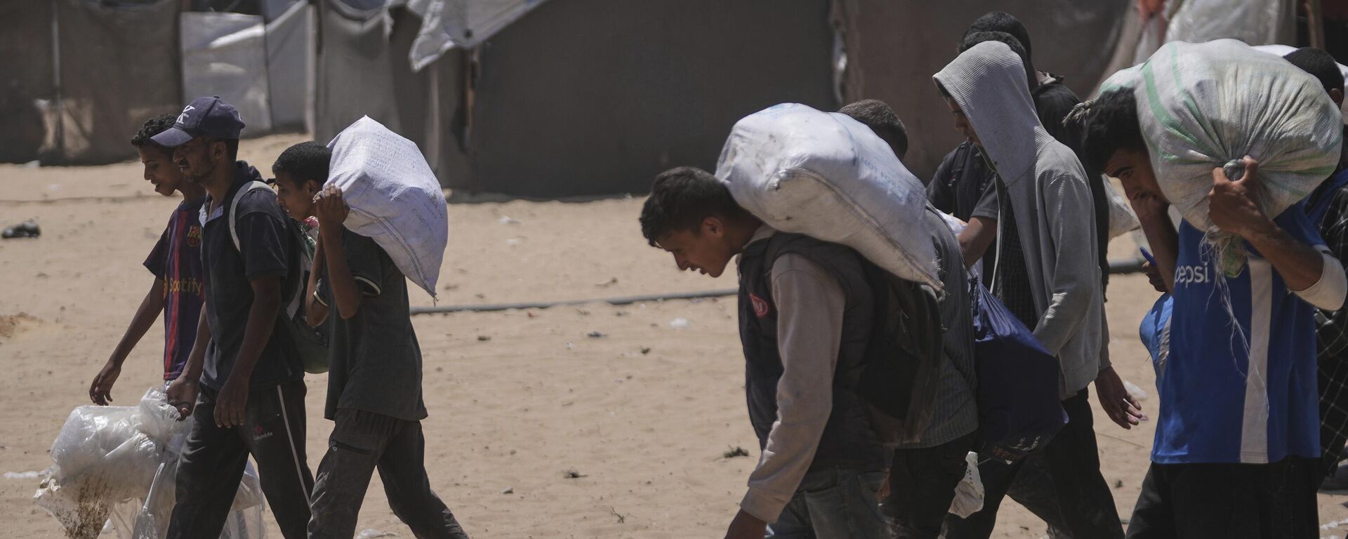 فلسطينيون يحملون أكياسًا من الطعام والمساعدات الإنسانية  في رفح، جنوب قطاع غزة - سبوتنيك عربي, 1920, 10.07.2025