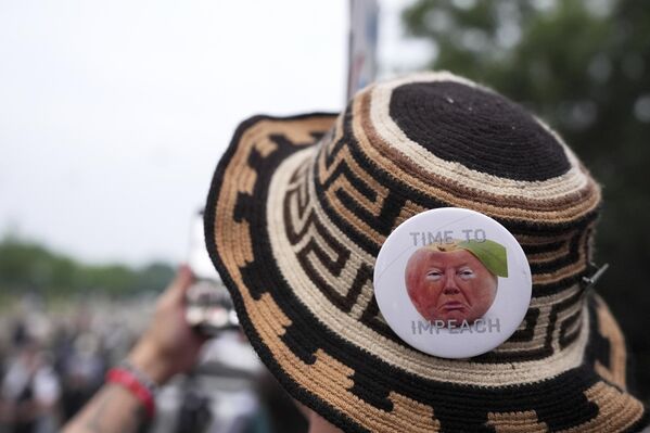 متظاهر يرتدي قبعة كتب عليها "حان وقت العزل" خلال احتجاج يوم عرض عسكري يُقام احتفالًا بالذكرى الـ 250 لتأسيس الجيش، بالتزامن مع عيد ميلاد الرئيس دونالد ترامب التاسع والسبعين، السبت 14 يونيو/حزيران 2025، في واشنطن. - سبوتنيك عربي