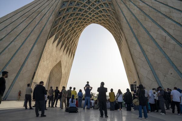 أناس يشاهدون الموسيقي الإيراني علي غمساري، وهو يؤدي موسيقى مناهضة للحرب في ساحة &quot;آزادي&quot; بطهران، بعد الساعات الأولى من شن الولايات المتحدة الأمريكية هجوما على 3 منشآت نووية إيرانية في نطنز وفوردو وأصفهان، ليلة 22 يونيو الجاري - سبوتنيك عربي