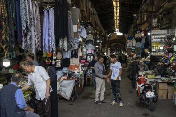 أناس يسيرون في سوق طهران المغلق جزئيًا، بعد الساعات الأولى من شن الولايات المتحدة الأمريكية هجوما على 3 منشآت نووية إيرانية في نطنز وفوردو وأصفهان، ليلة 22 يونيو/ حزيران الجاري - سبوتنيك عربي