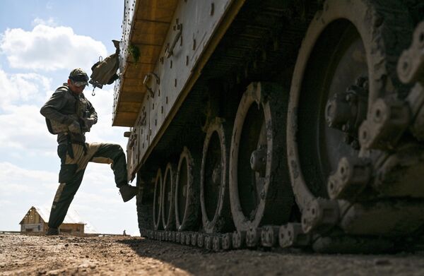 عسكري روسي يستعد للقيام باختبارات تشغيلية لمدرعة &quot;برادلي&quot; الأمريكية التي تم السيطرة عليها في منطقة العملية العسكرية الخاصة. - سبوتنيك عربي