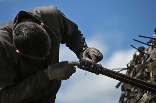 عسكري روسي يتفقد فوهة المركبة خلال الاختبارات التشغيلية تقوم بها القوات الروسية لمدرعة &quot;برادلي&quot; الأمريكية - سبوتنيك عربي