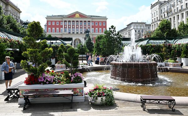 امرأة تستمتع بوقتها بين الورود ونافورة المياه وسط ساحة تفرسكايا. - سبوتنيك عربي