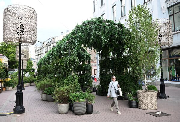 فتاة تمشي بين قوس من النباتات الخضراء في شارع أربات القديم. - سبوتنيك عربي