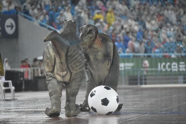  تمائم الديناصورات المحبوبة، التي تُذكّر بحديقة الديناصورات الشهيرة في تشانغتشو، تقدم عروضا لتشجيع اللاعبين قبل مباراة تجمع بين فريقي تشانغتشو ونانجينغ في دوري مدينة جيانغسو لكرة القدم 2025 في الصين. - سبوتنيك عربي