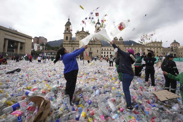 العاملون في مجال إعادة التدوير يلقون الزجاجات البلاستيكية في الهواء في ساحة بوليفار في بوغوتا، كولومبيا، احتجاجا على أسعار المواد المعاد تدويرها. - سبوتنيك عربي