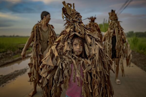 أشخاص يغطون أنفسهم بأوراق الموز والطين احتفالا بعيد القديس يوحنا المعمدان، في الفلبين. ويُعرف هذا الطقس باسم &quot;تاونغ بوتيك&quot; (شعب الطين). - سبوتنيك عربي