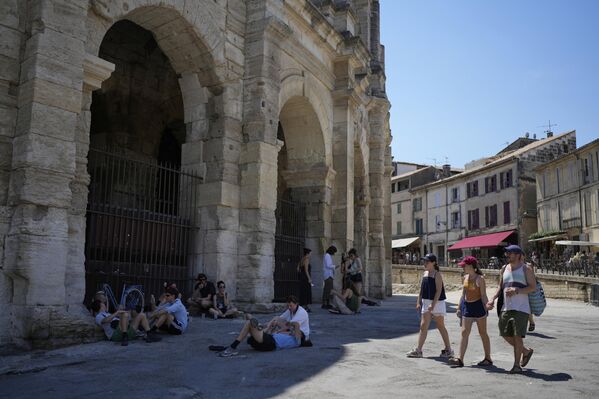يجلس الناس في ظل الساحات الرومانية القديمة خلال موجة الحر في آرل، جنوبي فرنسا. - سبوتنيك عربي