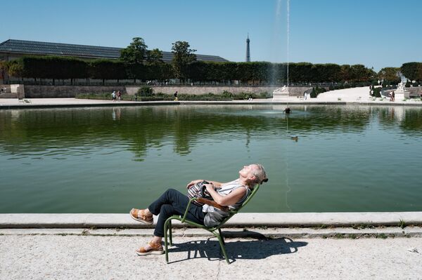 امرأة تجلس على كرسي في حديقة "تويلري"، حيث تجاوزت درجات الحرارة 40 درجة مئوية في باريس، فرنسا. - سبوتنيك عربي