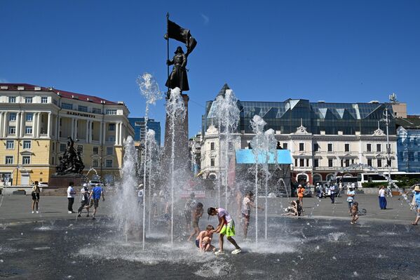 سكان مدينة فلاديفوستوك، يقصدون  النافورة &quot;الجافة&quot; في الساحة المركزية للهرب من من ارتفاع درجات الحرارة. - سبوتنيك عربي