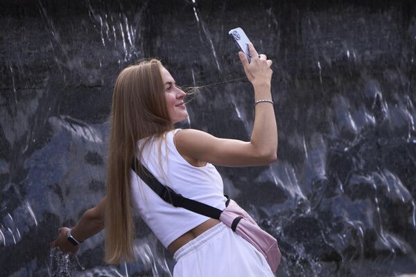 شابة تلتقط صورة سيلفي أثناء انتعاشها في نافورة في موسكو. - سبوتنيك عربي