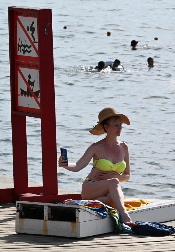 سيدة تلتقط صورة سيلفي أثناء استجمامها على ضفة نهر فلاديفوستوك. - سبوتنيك عربي