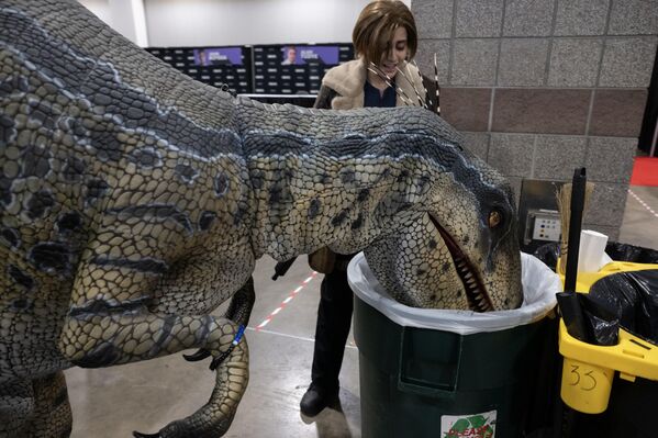 ضيف يرتدي زيّ ديناصور "فيلوسيرابتور" ينظر إلى سلة المهملات في معرض "فان إكسبو دنفر 2025"، في مركز مؤتمرات "كولورادو"، 4 يوليو 2025 - سبوتنيك عربي