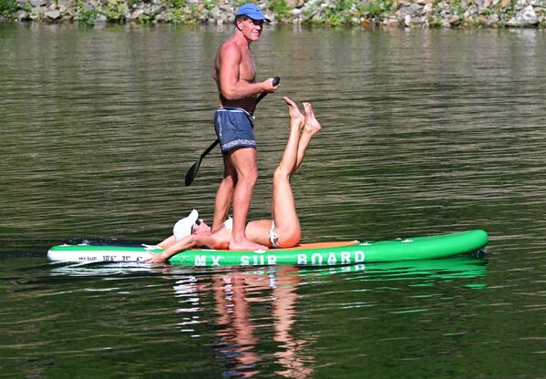 زوجان يجذفان في قارب، في يوم حار بأحد خلجان كراسنويارسك على نهر "ينيسي" بإقليم كراسنويارسك الروسي، إذ تجاوزت درجة حرارة الهواء في المناطق الوسطى والجنوبية من الإقليم 30 درجة مئوية، في عطلة نهاية الأسبوع الأولى، من شهر يوليو الجاري - سبوتنيك عربي