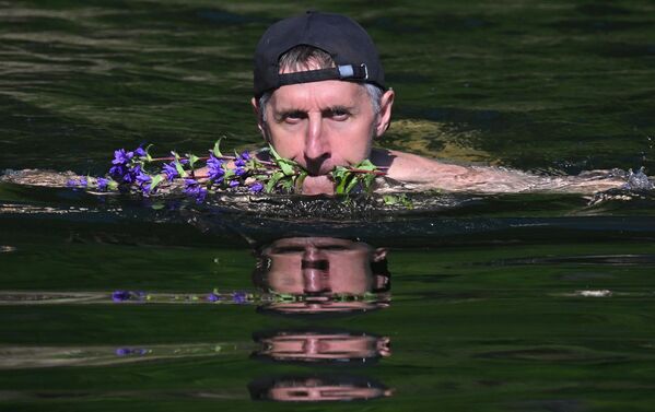 رجل يُهدي حبيبته أزهارًا برية في يومٍ حارٍ في أحد خلجان كراسنويارسك، على نهر "ينيسي" بإقليم كراسنويارسك الروسي - سبوتنيك عربي