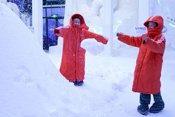 أطفال يلعبون في معرض "صن آيلاند" للفنون الجليدية والثلجية في هاربين، الصين. - سبوتنيك عربي
