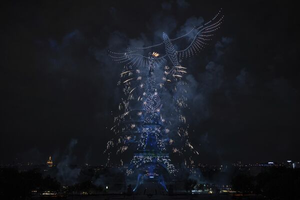 الألعاب النارية والطائرات المسيرة تضيء برج "إيفل" في باريس، خلال احتفالات "يوم الباستيل" (العيد الوطني)، فرنسا - سبوتنيك عربي