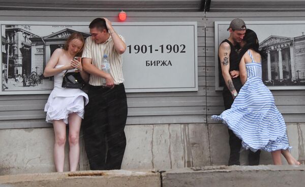 سكان في العاصمة الروسية موسكو يحتمون من المطر - سبوتنيك عربي